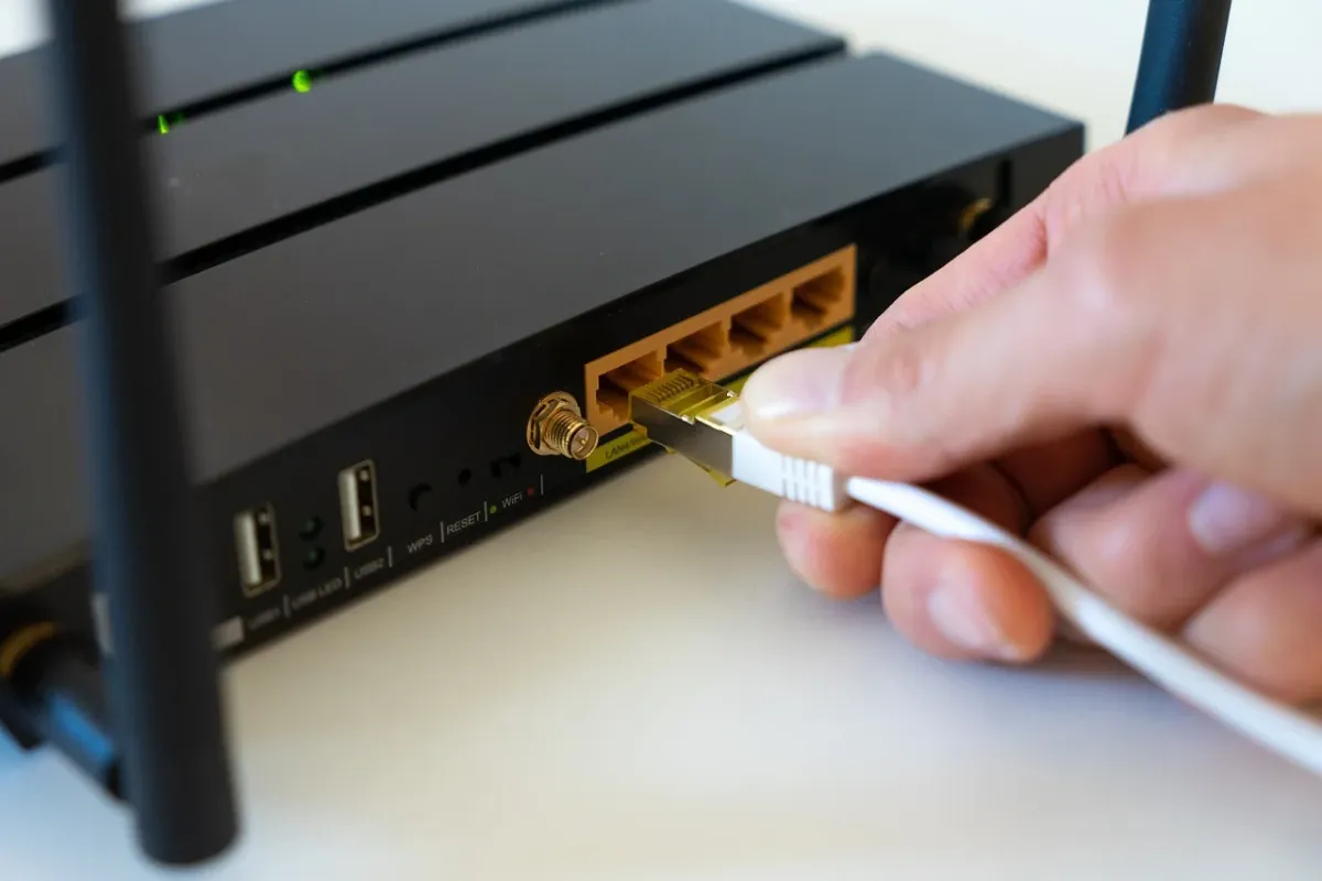 Router internetowy z podłączonym modemem i anteną, zapewniający stabilne połączenie z siecią.